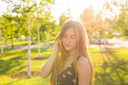 年轻漂亮的女人，在背景中的日落公园享受她以外的时间
