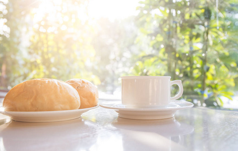 杯咖啡，在桌子上的面包