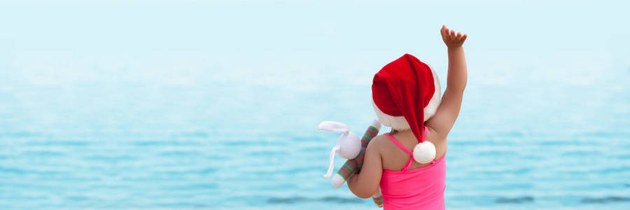 在圣诞老人的帽子在海上寻找的女孩