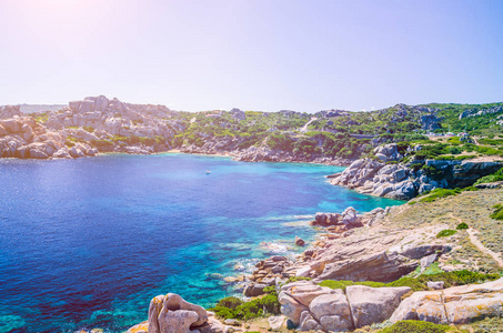 奇异的花岗岩岩石和 azure 湾与太阳耀斑在投诉警察课种皮，撒丁岛，意大利