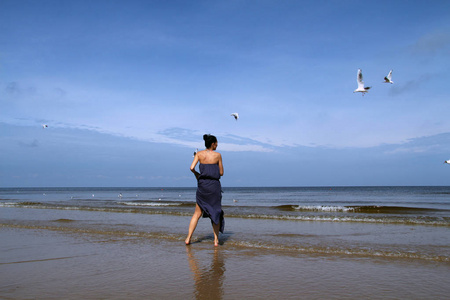 波罗地海，女人赤脚行走沿着海滩和忱