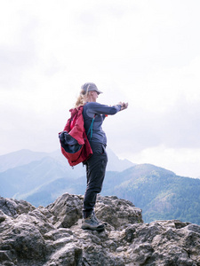 一个女人在这座山的顶部拍照智能手机