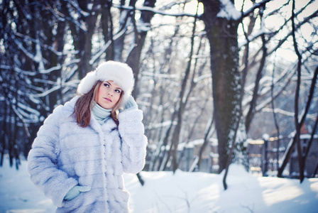 美丽的女孩在一个下雪的冬天公园
