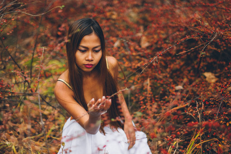 时尚华丽的年轻女人美丽的白色礼服，在一个童话般的森林。魔幻气氛