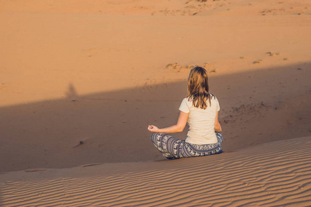 冥想在沙漠中的年轻女子