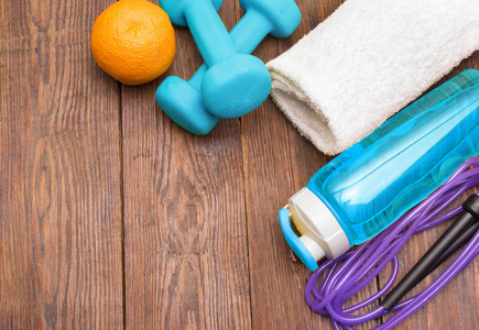健身器材。健康的食物。运动鞋，水，跳绳和橙色