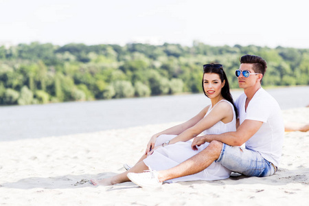 年轻夫妇坐在海滩