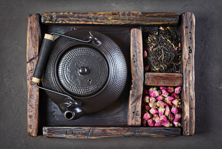 亚洲黑色传统茶壶干茶与玫瑰在老式的木盒子里