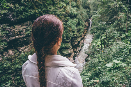 徒步旅行者年轻女人享受着与山区河流的山谷景色