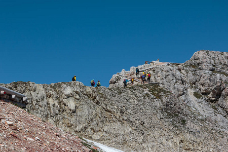 旅游者和登山者在贫瘠的群山间的石板小路散步