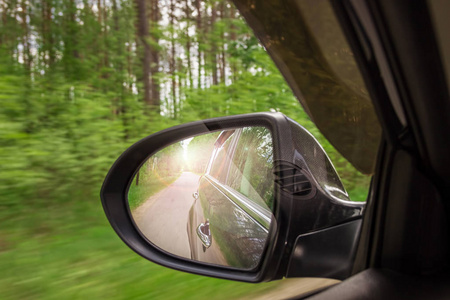 在侧后视镜的视图。镜子后一辆车。这条路的思考