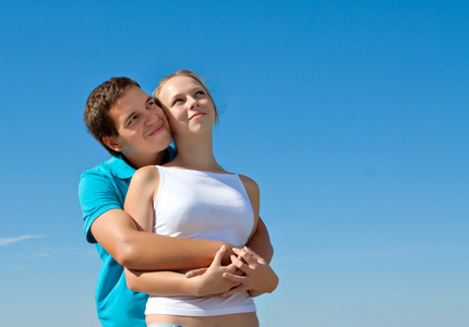 年轻夫妇拥抱并仰望天空