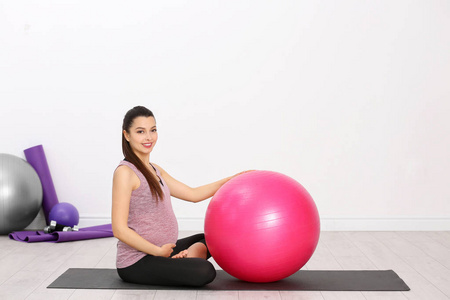 年轻的孕妇，在健身房训练。健康概念