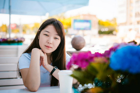 可爱的亚洲年轻女子夏季咖啡馆户外