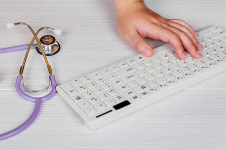 听诊器与剪贴板和笔记本电脑在桌上，医生在处方书写的医院工作