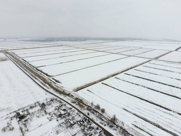 顶视图的犁过的田野,在冬天.一片麦田在雪中