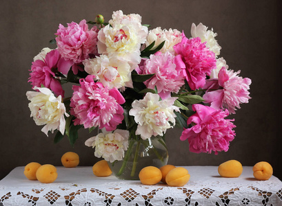粉色和白色的牡丹。花在花瓶里和杏子 ta