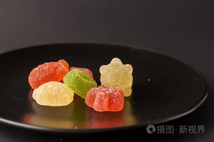 五彩缤纷的糖果的特写镜头.混合的水果味果冻在黑色印版上