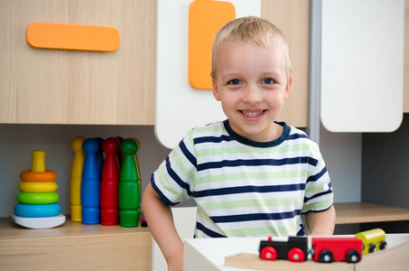 儿童男孩玩木制火车在幼儿园