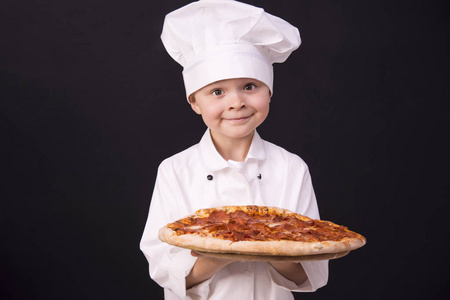 持有意大利腊肠披萨的男孩厨师
