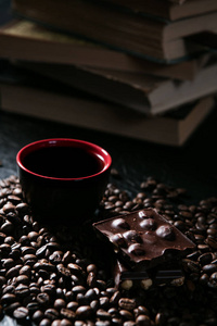 咖啡杯和咖啡豆和巧克力对书的背景