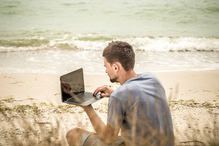 在计算机上运行的人工作在沙滩上