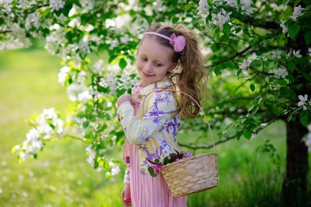 一篮鲜花在夏日盛开的苹果树美丽微笑着可爱的小女孩