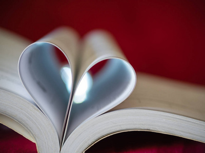特写镜头柔焦页的一本书弯成一个心形。爱和情人节的概念