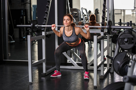 肌肉锻炼在健身房在模拟器上的年轻女子