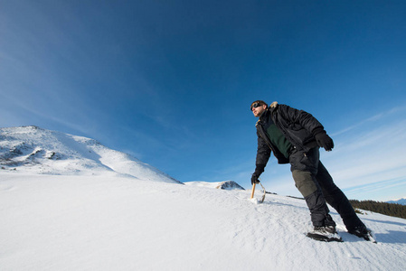 用冰斧在雪山的登山者