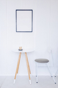 一张桌子，灰色的椅子和淡灰色的墙上挂着一张海报与厨房的一角