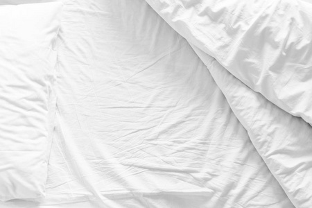 凌乱的床上，与张皱巴巴的床单 毛毯和枕头舒适羽绒被睡眠在早晨醒来后