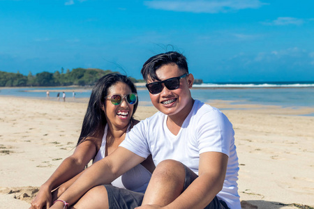 亚洲夫妻坐在海滩的热带巴厘岛，印度尼西亚