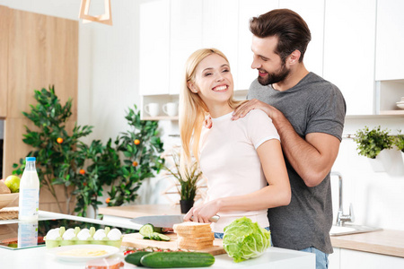 英俊的男人和他的女朋友在家里做饭