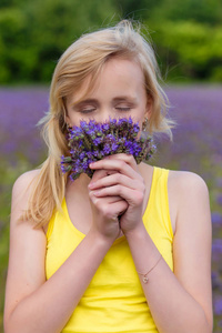 一个女孩在户外夏季紫色花朵的特写肖像