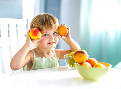 可爱的小女孩，用手在桌里的桃子