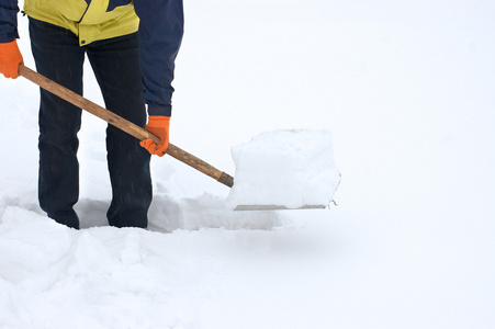 从雪地上挖一条路的人