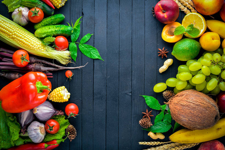 大生蔬菜和水果在黑色的木桌上的选择。您的文字的的自由空间。顶视图