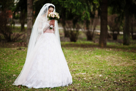 可爱的新娘，在公园与一束构成上的肖像