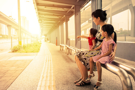 亚洲的中国母亲和女儿等一辆公交车