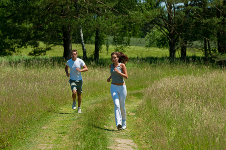 年轻夫妇在春天自然的户外慢跑
