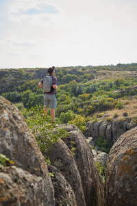 在山的眺望，背包里的年轻人。一名游客在自然背景