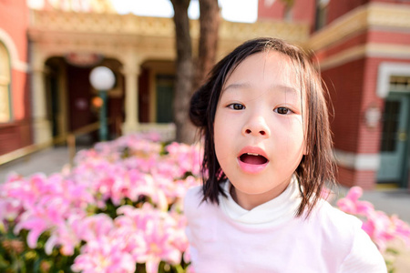 可爱的亚洲女孩粉红色的花场户外与自然轻