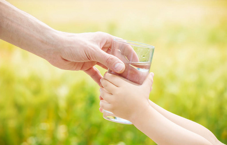 父亲给孩子一杯水。选择性的焦点