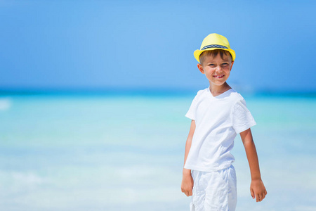 在热带海洋沙滩上玩耍的男孩。孩子在家庭海度假期间