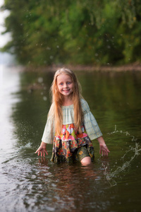 美丽的童话女孩与长长的头发站在河里一片森林。在这条河的童话女孩美人鱼