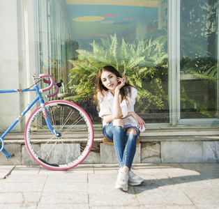 坐在老式自行车附近的女孩
