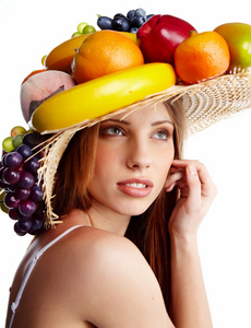一个带水果头饰的漂亮年轻女人的照片。 食物