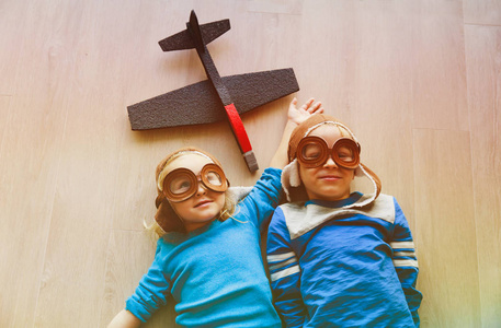 快乐的孩子，头盔和眼镜玩玩具飞机