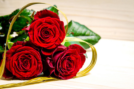 美丽的红玫瑰被笼罩在金色的丝带, 它有一个心形